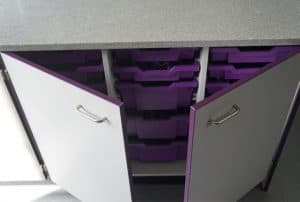 Velstone work top with grey cupboard featuring purple contract edging and purple singe and double Gratnells’ Trays.