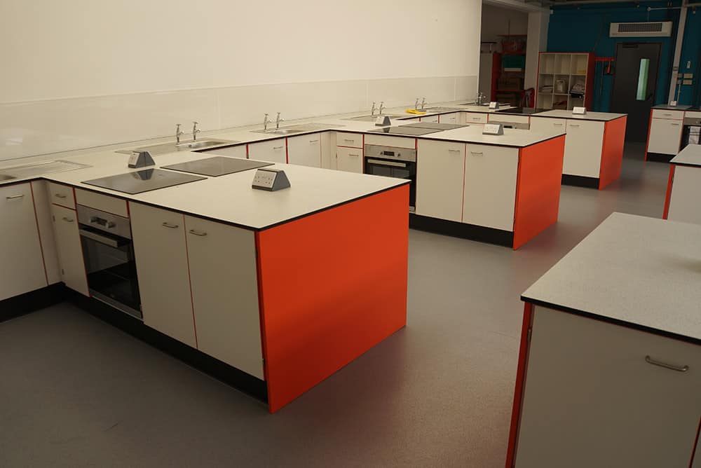 The Lakes School food technology classroom cabinets with orange contrast edging.