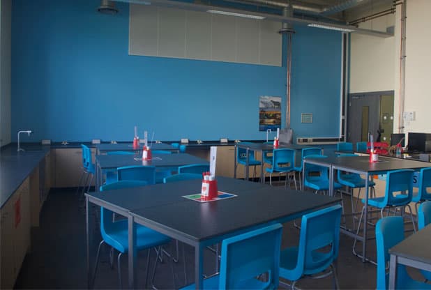 Co-op Academy Manchester Science laboratory with exposed ceilings and pipework.