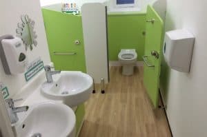 Green primary school sinks and toilet cubicles.