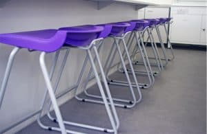 Contrast purple stools in school science lab.