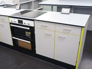 Food Technology Classroom Design for Special Needs School with Trespa worktops, white doors & contrast lime edge